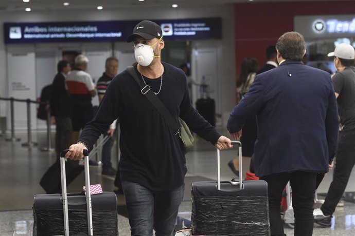 Un turista con mascarilla en un aeropuerto de Argentina por el coronavirus.