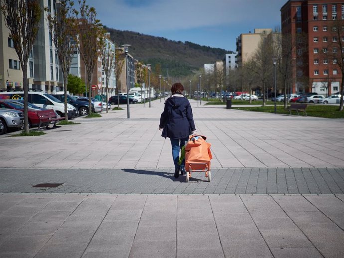 Una mujer transita por la ciudad después de realizar la compra de alimentos durante el período de confinamiento durante el estado de alarma por coronavirus, covid-19. En Pamplona, Navarra (España) a 27 de marzo de 2020.