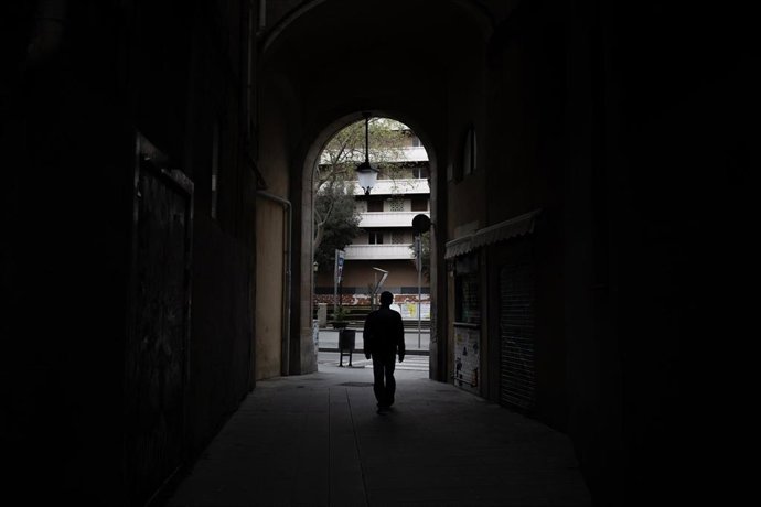 Una persona camina por un pasadizo durante el primer día laborable de la segunda semana desde que se decretó el estado de alarma en el país a consecuencia del coronavirus, en Barcelona/Catalunya (España) a 23 de marzo de 2020.