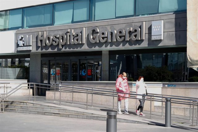 Dos personas protegidas con mascarillas salen del Hospital La Paz.