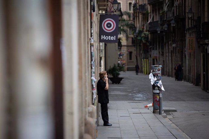 Una mujer habla por teléfono durante el segundo día laborable del estado de alarma por el coronavirus en Barcelona (España)