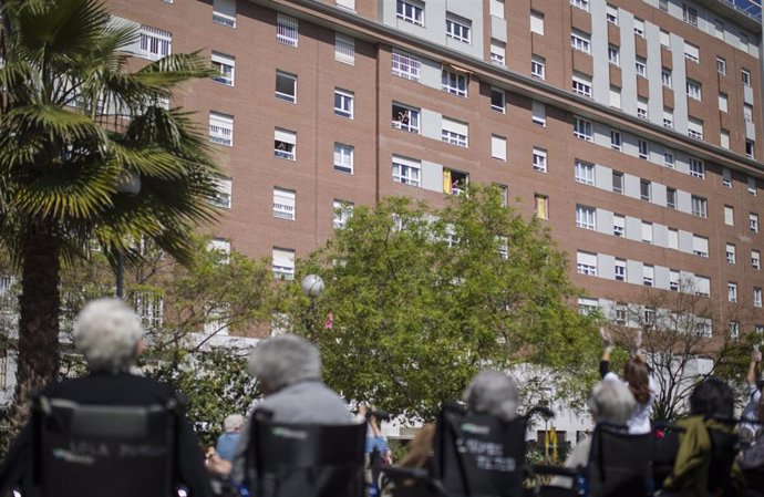 Vecinos del barrio saludan desde sus ventanas a los ancianos de la residencia de mayores Vitalia Kansas. En Sevilla, (Andalucía, España), a 26 de marzo de 2020.