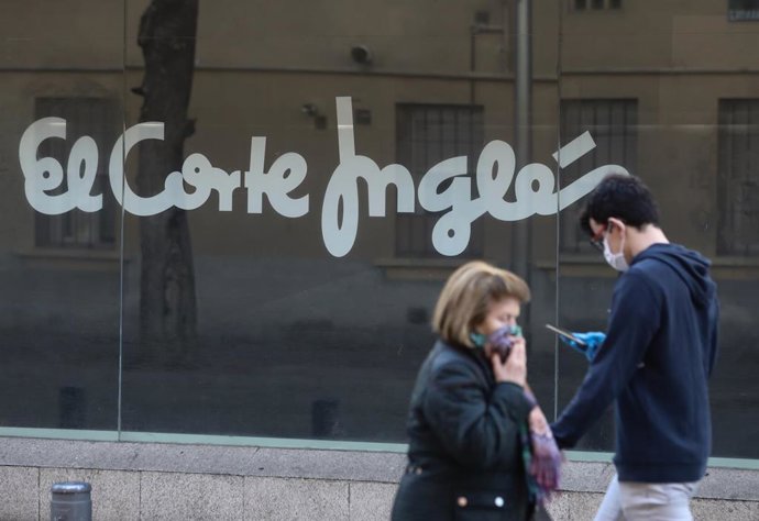 Una mujer y un joven pasan al lado de uno de los centros del Corte Inglés de la capital