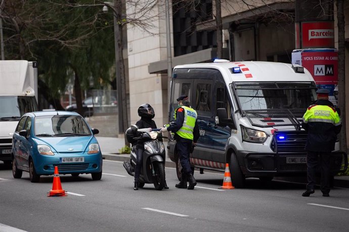 Dos Mossos d'Esquadra en un control de tráfico en la calle Balmes con la Avenida Diagonal de Barcelona para vigilar que se cumplen las medidas de confinamiento