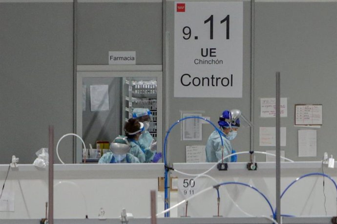 Sanitarios protegidos con mascarillas, gorros y pantallas protectoras en la puerta del almacén de material farmacéutico en el Hospital temporal de la Comunidad de Madrid habilitado en IFEMA para pacientes con coronavirus, en Madrid (España) a 31 de marzo