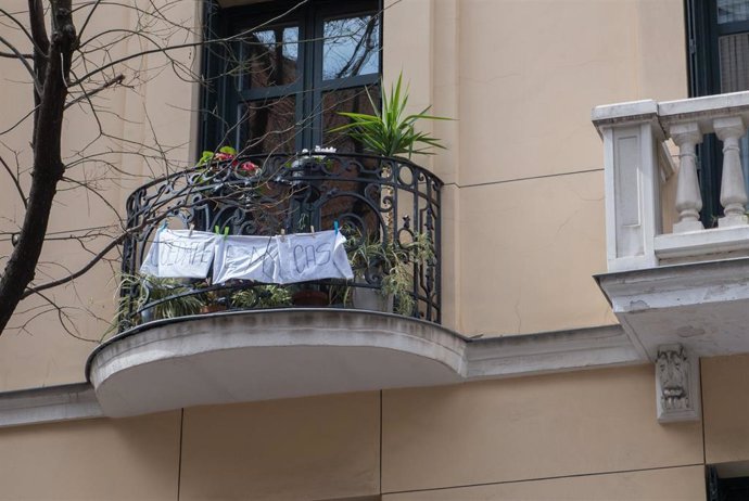 Pancarta en un balcón en la que se lee 'QUÉDATE EN CASA', durante el primer día laborable de la segunda semana desde que se decretó el estado de alarma en el país a consecuencia del coronavirus, en Madrid (España), a 23 de marzo de 2020.
