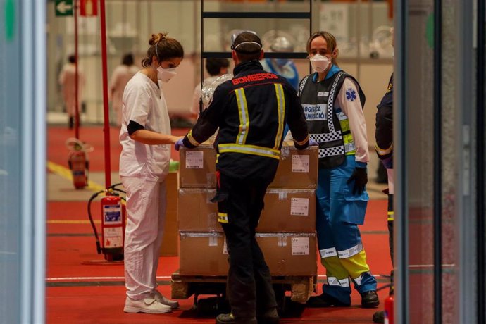 Una enfermera, un bombero y un técnico sanitario conversan en el interior del hospital Temporal de la Comunidad de Madrid en IFEMA para pacientes con Covid-19, en Madrid el 31 de marzo de 2020.