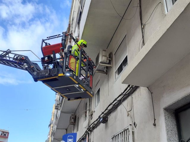 Un bombero trata de acceder a la vivienda donde se ha localizado a la persona caída.