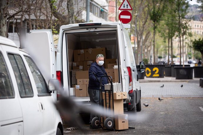Un hombre protegido con mascarilla trabaja de repartidor durante el noveno día laborable desde que se decretó el estado de alarma en el país a consecuencia del coronavirus, en Barcelona/Catalunya (España) a 26 de marzo de 2020.