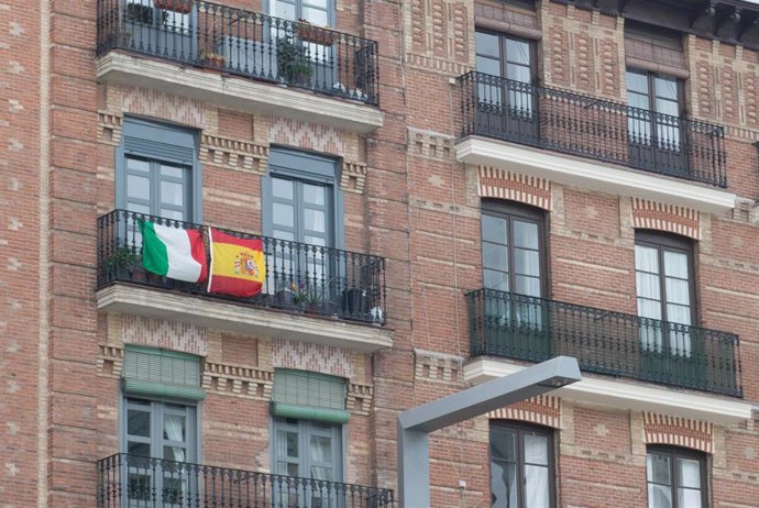 Balcón con las banderas de Italia y España, durante el primer día laborable de la segunda semana desde que se decretó el estado de alarma en el país a consecuencia del coronavirus, en Madrid (España), a 23 de marzo de 2020.