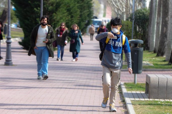 Un alumno con mascarilla pasea por el campus de la Universidad Autónoma de Madrid antes de la suspensión de las clases por el coronavirus.