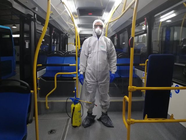 Operario desinfectando un autobús urbano.