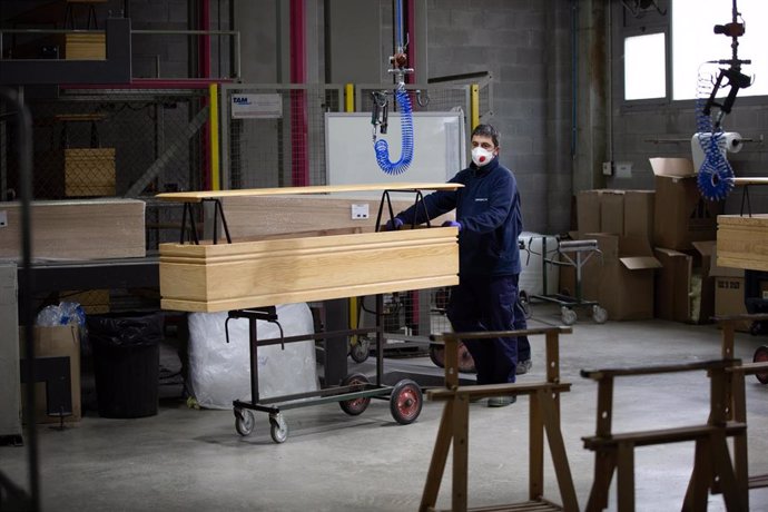 Un trabajador de la empresa Eurocoffin, la fábrica de ataúdes de Serveis Funeraris de Barcelona - Grupo Mémora, ubicada en la montaña de Montjuc de Barcelona, trabaja con la madera de uno de sus ataúdes durante su jornada laboral. 