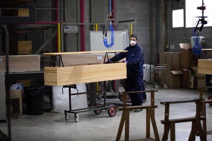 Un treballador de l'empresa Eurocoffin, la fbrica de taüts de Serveis Funeraris de Barcelona - Grup Mémora, situada a la muntanya de Montjuc de Barcelona, treballa amb la fusta d'un dels seus taüts durant la seva jornada laboral. 
