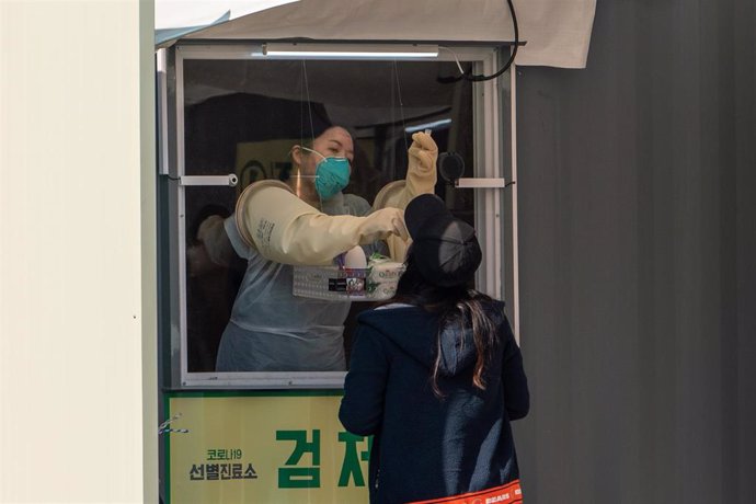 Una trabajadora de los equipos médicos de Seúl, Corea del Sur, toma una muestra a una ciudadana.