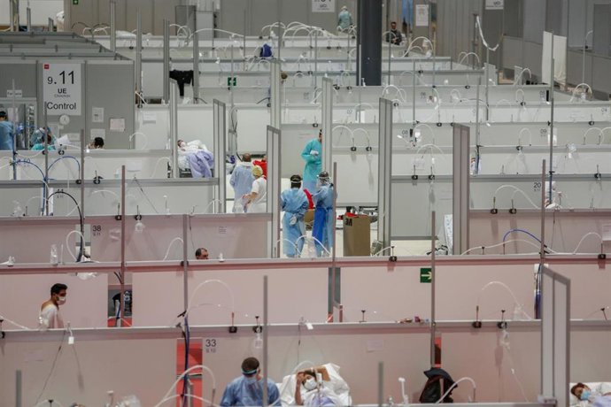 Dos sanitarios protegidos trabajan en el interior del Hospital temporal de la Comunidad de Madrid habilitado en IFEMA para pacientes con coronavirus, en Madrid (España) a 3 de abril de 2020.