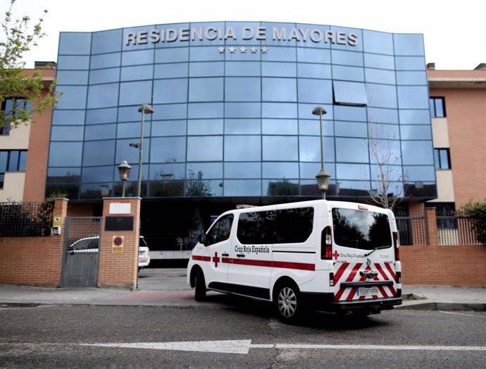 Un coche y una furgoneta de la Cruz Roja llegan a la Residencia de Mayores Los Ángeles, en Getafe (Madrid).
