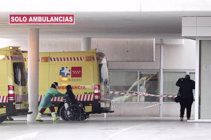 Una sanitaria empuja una silla con un paciente en la entrada de Urgencias del Hospital de Fuenlabrada