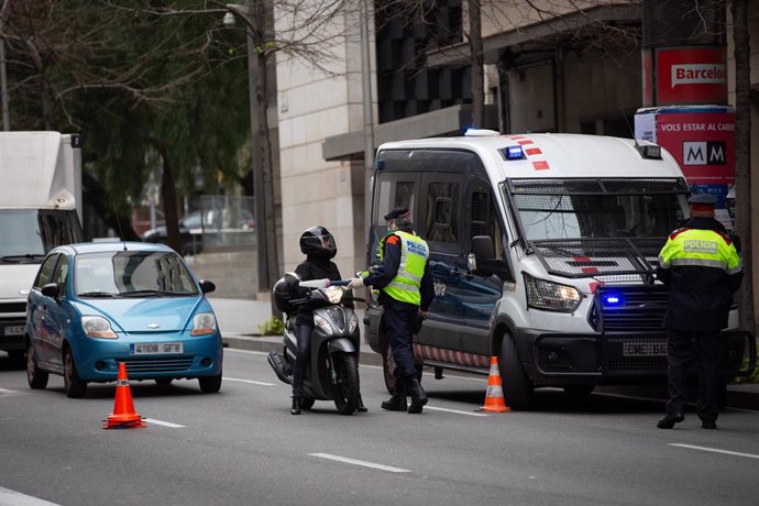 Dos Mossos d'Esquadra en un control de trnsit al carrer Balmes amb l'Avinguda Diagonal de Barcelona per vigilar que es compleixen les mesures de confinament, a Barcelona/Catalunya (Espanya) a 31 de mar de 2020.