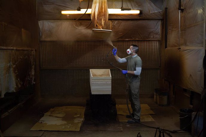 Un trabajador de la empresa Eurocoffin, la fábrica de ataúdes de Serveis Funeraris de Barcelona - Grupo Mémora, ubicada en la montaña de Montjuc de Barcelona, trabaja con la madera de uno de sus ataúdes durante su jornada laboral