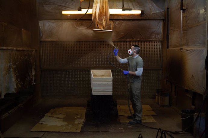Un treballador de l'empresa Eurocoffin, la fbrica de taüts de Serveis Funeraris de Barcelona - Grup Mémora, situada a la muntanya de Montjuc de Barcelona, treballa amb la fusta d'un dels seus taüts durant la seva jornada laboral