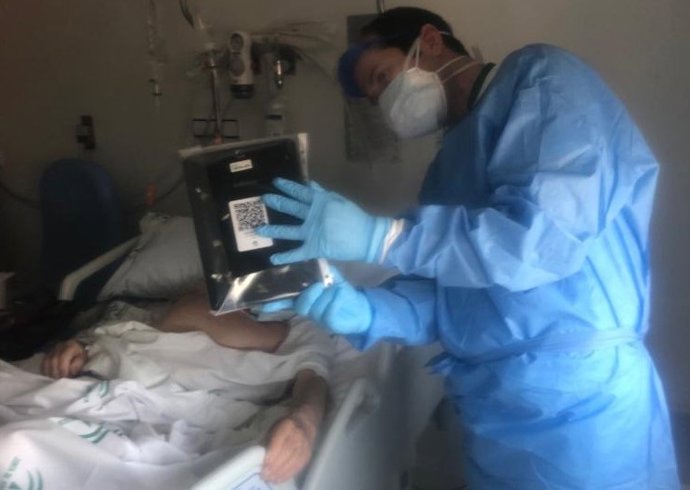 Un enfermero comunica a una paciente con Covid-19 con un familiar