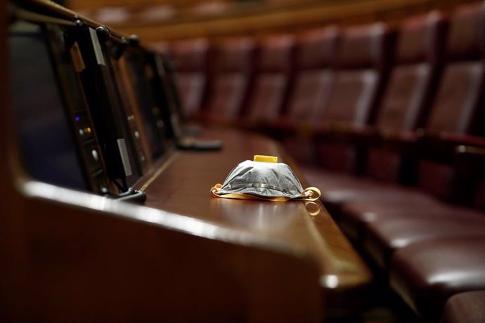 Una mascarilla de protección en un escaño durante el Pleno del Congreso que debatió la ampliación del vigente estado de alarma