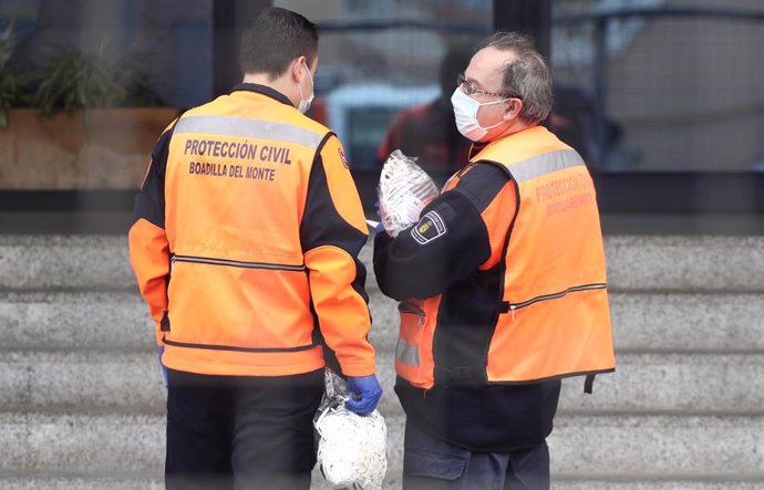 Dos agentes de Protección Civil de Boadilla del Monte protegidos con mascarillas llevan mascarillas a la Residencia de Mayores Los Ángeles en Getafe para la protección contra el coronavirus, en Getafe (Madrid) a 6 de abril de 2020.