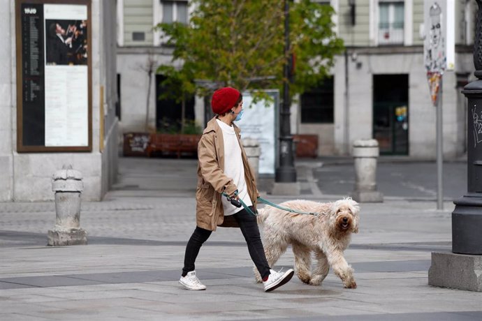 Una mujer pasea a su perro durante el primer día de la cuarta semana de estado de alarma decretado por el Gobierno para combatir el coronavirus, en Madrid (España) a 6 de abril de 2020.