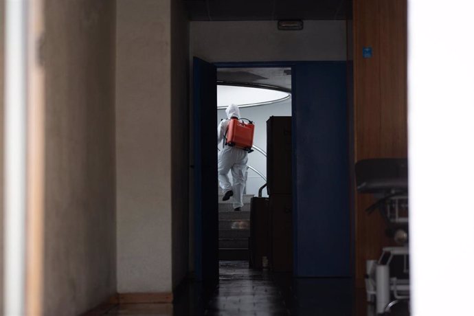 Un militar de la UME con traje de protección desinfecta espacios de una residencia geriátrica en Barcelona