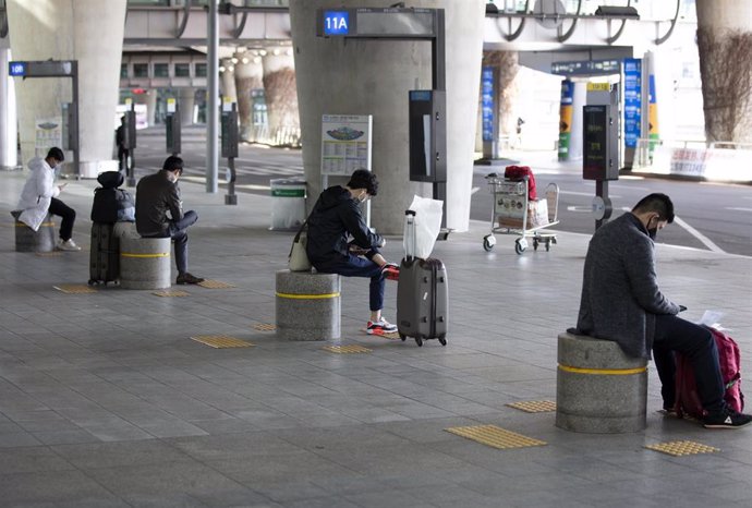 Ciudadanos surcoreanos mantienen las distancias de seguridad en la terminal del Aeropuerto Internacional de Incheon.