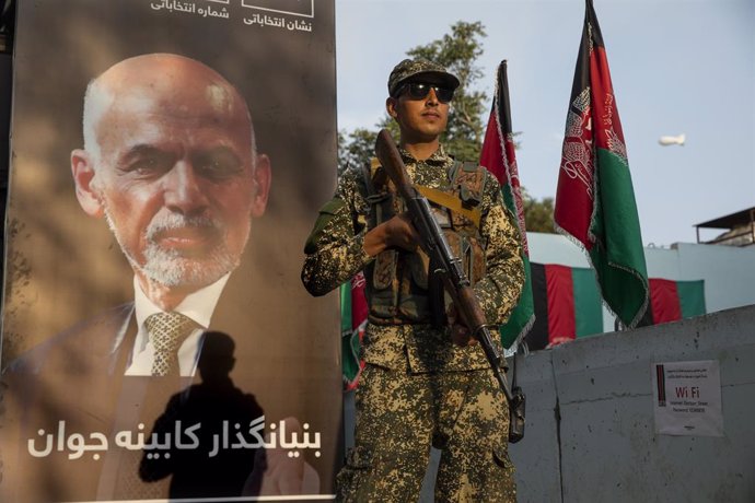 Militar afgano frente a un cartel de Ashraf Ghani