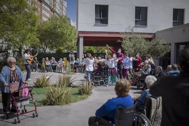 Personal y usuarios de la residencia de mayores Vitalia Kansas salen al patio durante unos minutos para celebrar que no hay ningún caso de contagio por coronavirus hasta la fecha, esta.  En Sevilla, (Andalucía, España), a 26 de marzo de 2020.