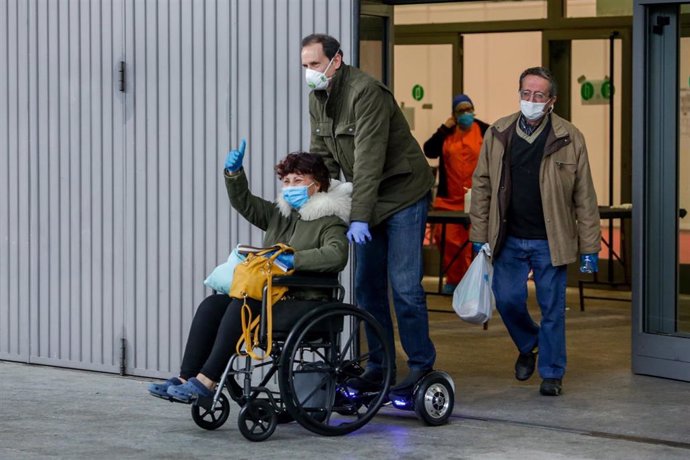 Un familiar recoge a una paciente con coronavirus que abandona el Hospital temporal de la Comunidad de Madrid habilitado en Ifema