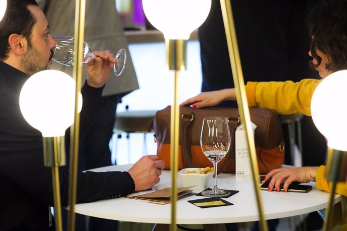 Dos personas beben una copa de vino, en Madrid (España) a 24 de febrero de 2020.