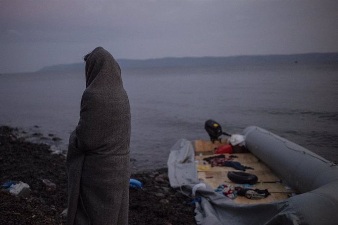 01 March 2020, Greece, Lesbos: A migrant wrapped in blankets stands next to a dinghy at the village of Skala Sikaminias, after crossing the Aegean Sea from Turkey in a dinghy. Photo: Angelos Tzortzinis/dpa