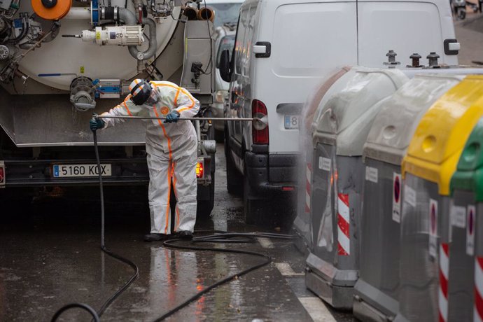 Un treballador desinfecta i neteja els contenidors d'escombraries de Barcelona durant la tercera setmana de confinament per la crisi del coronavirus