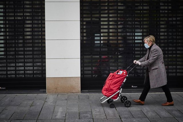 Una mujer protegida con mascarilla camina con un carro de la compra durante la cuarta semana del estado de alarma, en Pamplona (Navarra) a 6 de abril de 2020.
