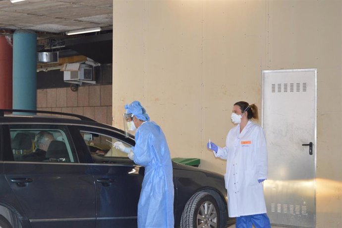 Dos profesionales sanitarios recogen muestras a un paciente sin que este baje del coche en el Centro Intermedio de Control.