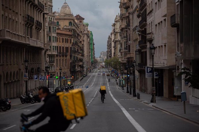 Dos trabajadores de Glovo en bicicleta por Barcelona el primer día laborable de la segunda semana del estado de alarma