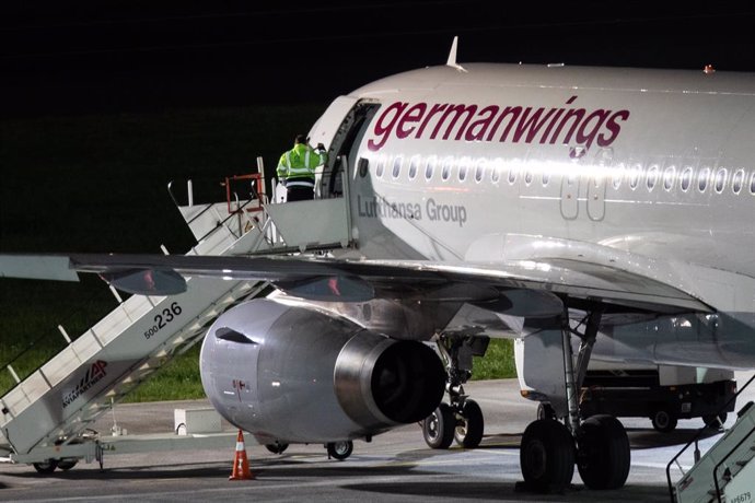 30 December 2019, Duesseldorf: An airport employee closes the door of a machine belonging to the airline Germanwings, which is standing on the apron during a strike called by the cabin crew union (Ufo). Germanwings carries out its flights for Eurowings.