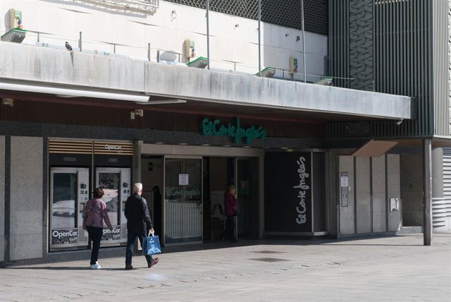 Dos transeúntes pasan frente a la entrada del edificio de El Corte Inglés