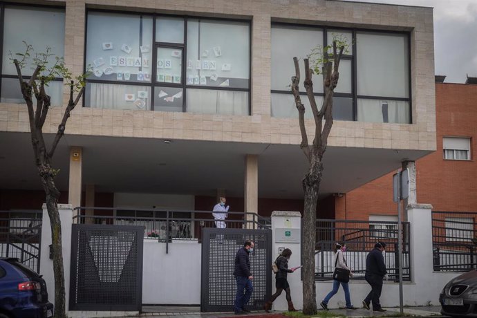 Un grupo de personas sale del centro de personas mayores Joaquín Rosillo de San Juan de Aznalfarache (Sevilla), donde la Junta de Andalucía ha confirmado 79 casos de coronavirus Covid-19 y la muerte de 24 de los ancianos   
