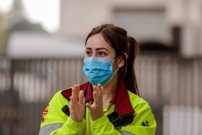 Una sanitaria protegida con mascarilla aplaude durante el homenaje en las inmediaciones de la Fundación Jiménez Díaz a todo el personal sanitario