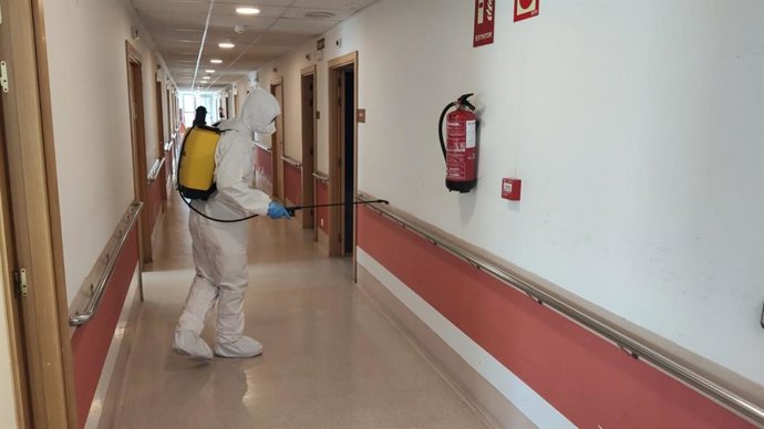 Un miembro de la UME desinfectando.