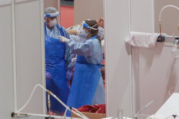 Dos sanitarios protegidos trabajan en el interior del Hospital temporal de la Comunidad de Madrid habilitado en IFEMA para pacientes con coronavirus, en Madrid (España) a 3 de abril de 2020.
