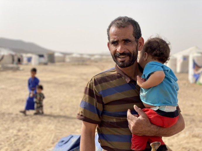 Un yemení desplazado por el conflicto junto a su hijo en el campamento de Marib.