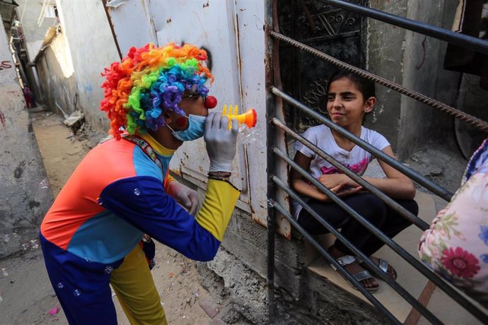 Un hombre palestino, disfrazado de payaso, entretiene a niños y niñas confinados en casa por el coronavirus.