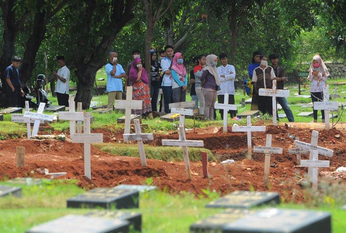 Personas con mascarilla por el coronavirus en un cementerio de Yakarta (Indonesia)