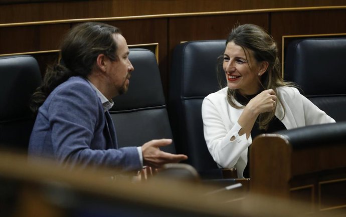 La ministra de Trabajo, Yolanda Díaz, habla con el vicepresidente de Derechos Sociales y para la Agenda 2030, Pablo Iglesias, durante el pleno celebrado este jueves en el Congreso de los Diputados.